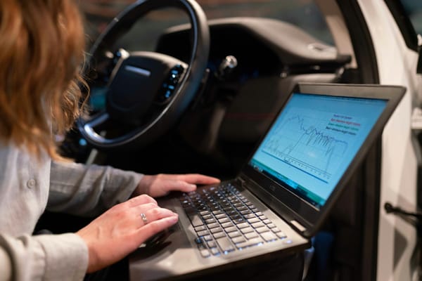 Tècnica realitzant un diagnòstic electrònic d'un vehicle amb un portàtil connectat a l'interior del cotxe